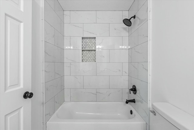 bathroom with tiled shower / bath and toilet