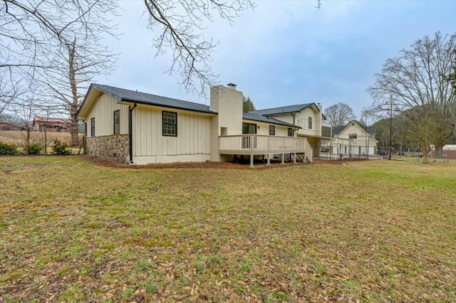 rear view of house with a yard and a deck