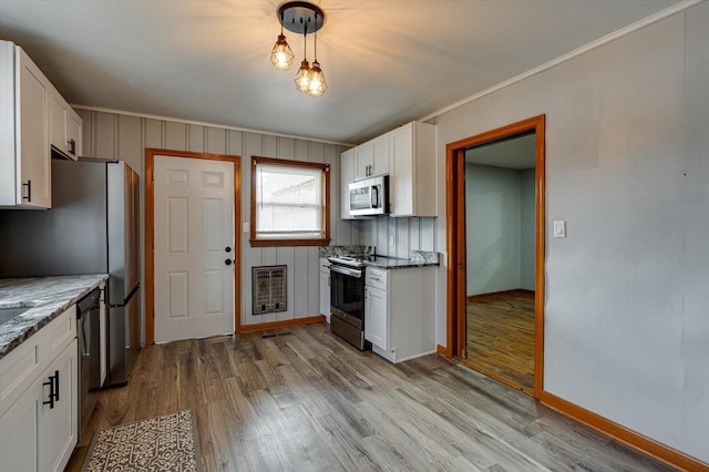 kitchen with light hardwood / wood-style flooring, appliances with stainless steel finishes, light stone counters, heating unit, and white cabinets