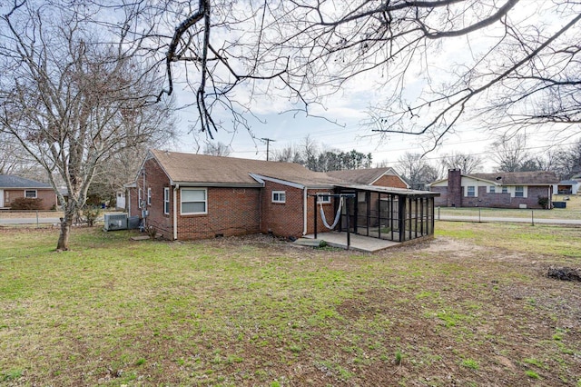 rear view of property featuring a patio, a sunroom, and a yard