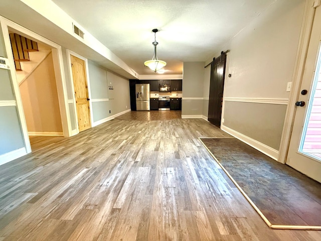 interior space with dark hardwood / wood-style flooring and a barn door