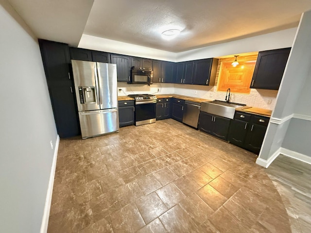 kitchen featuring stainless steel appliances, sink, and decorative backsplash