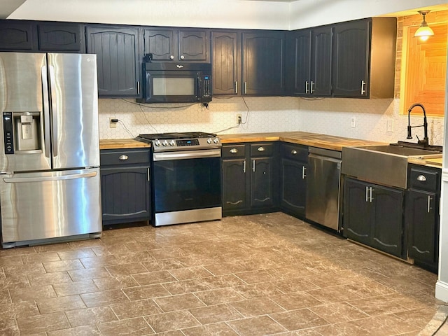 kitchen with sink, decorative backsplash, wooden counters, and appliances with stainless steel finishes