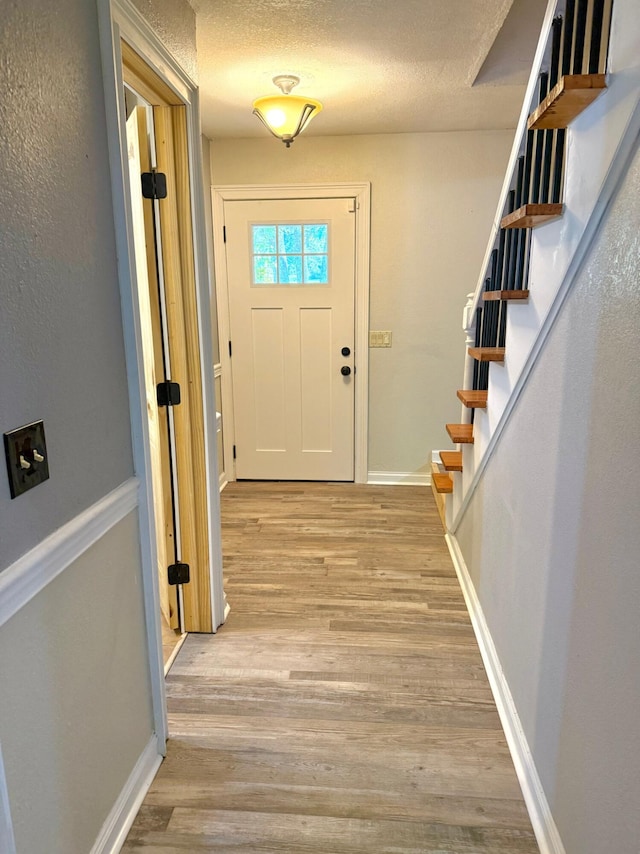 foyer featuring light hardwood / wood-style flooring and a textured ceiling