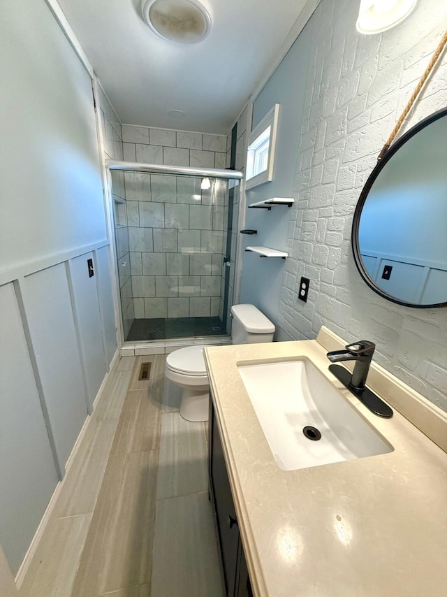 bathroom with walk in shower, vanity, and toilet