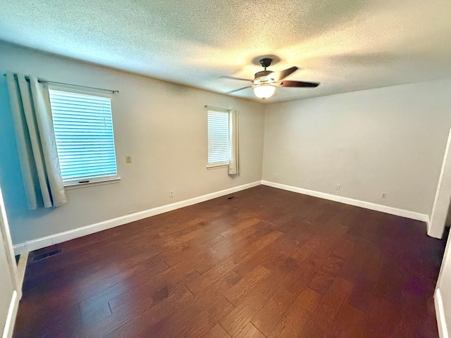 empty room with ceiling fan, dark hardwood / wood-style floors, and a textured ceiling