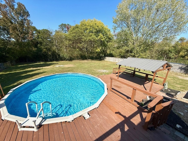 view of swimming pool with a yard and a deck