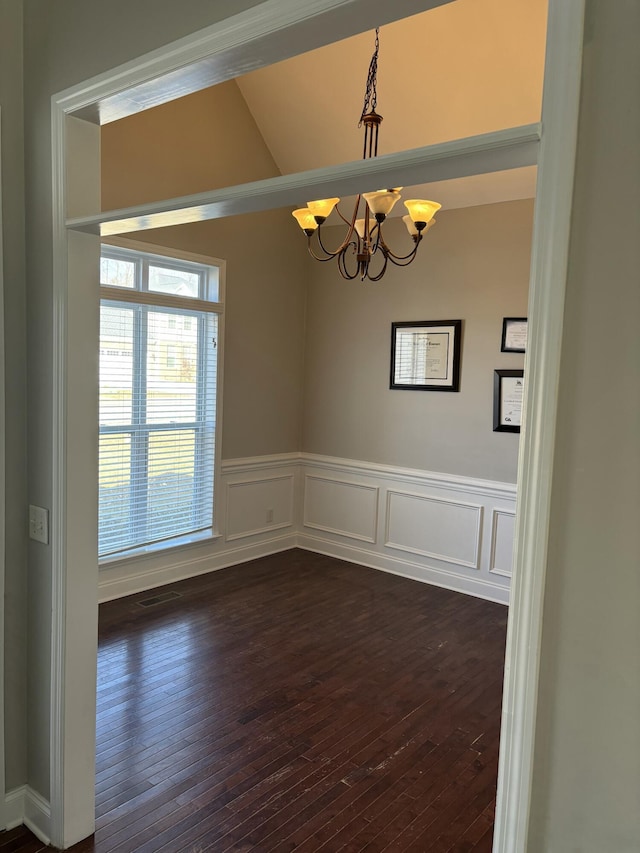 unfurnished room with dark hardwood / wood-style flooring and an inviting chandelier