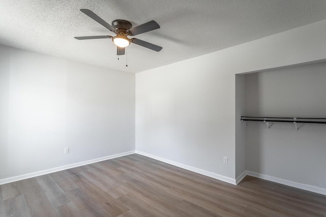 unfurnished bedroom with ceiling fan, wood-type flooring, and a textured ceiling