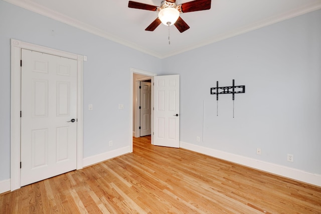 spare room with ceiling fan, baseboards, light wood-style floors, and ornamental molding