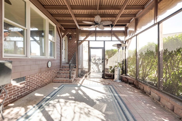 unfurnished sunroom with ceiling fan