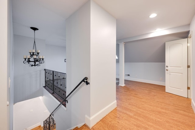 hall featuring baseboards, light wood finished floors, an inviting chandelier, recessed lighting, and an upstairs landing
