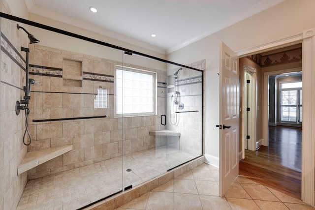 bathroom with tile patterned floors, a stall shower, and ornamental molding