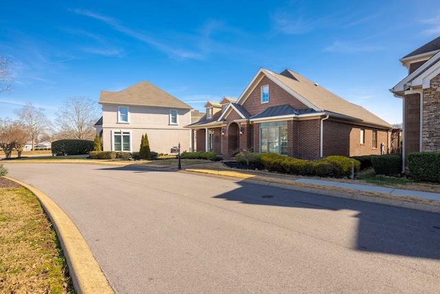 traditional-style house featuring brick siding, metal roof, and a standing seam roof