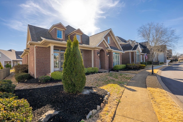 view of front of property with brick siding, a residential view, and fence