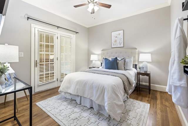 bedroom with baseboards, wood finished floors, crown molding, and access to outside