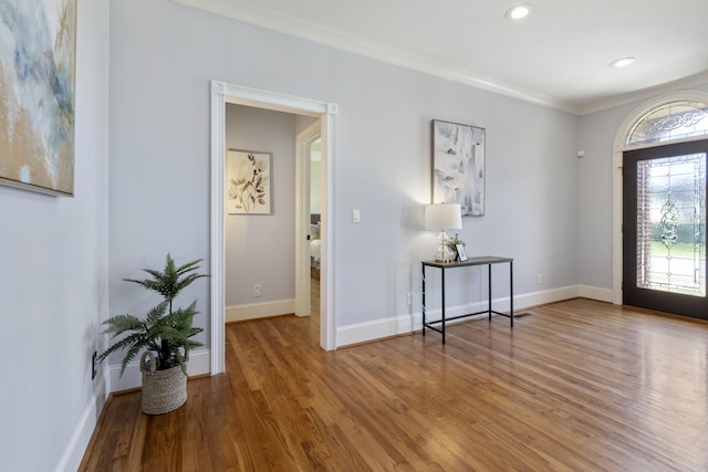 foyer with recessed lighting, baseboards, wood finished floors, and ornamental molding