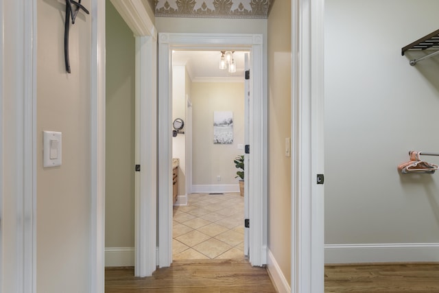hallway featuring wood finished floors, baseboards, and ornamental molding