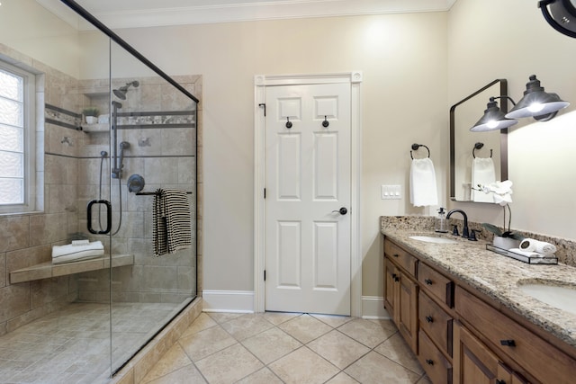 bathroom with tile patterned flooring, crown molding, double vanity, a stall shower, and a sink