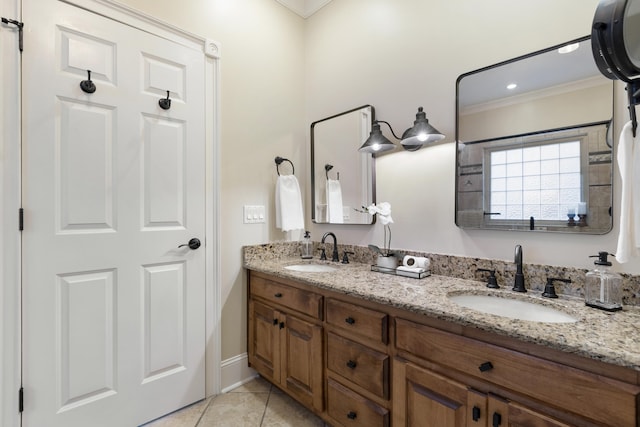 bathroom featuring a sink, double vanity, crown molding, and tile patterned flooring