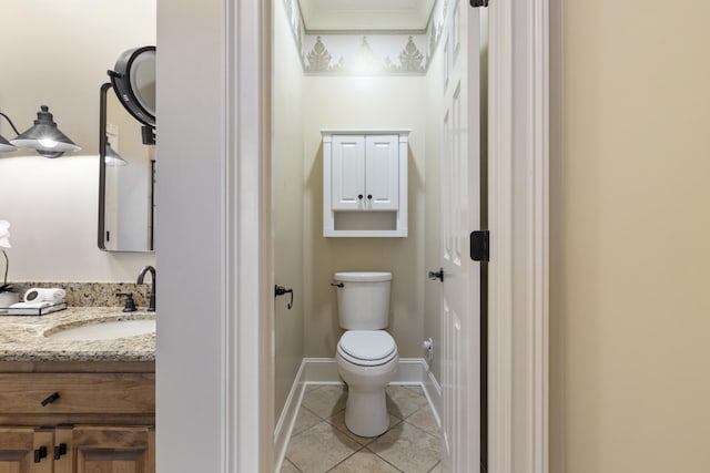 bathroom with baseboards, toilet, vanity, and tile patterned flooring
