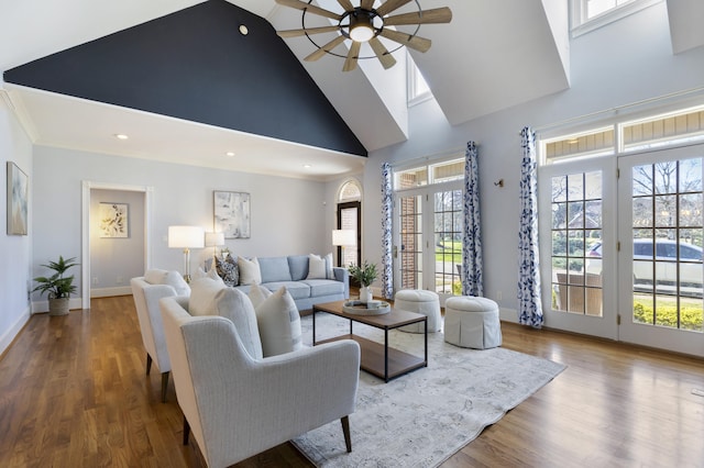 living room with wood finished floors, a wealth of natural light, and ceiling fan