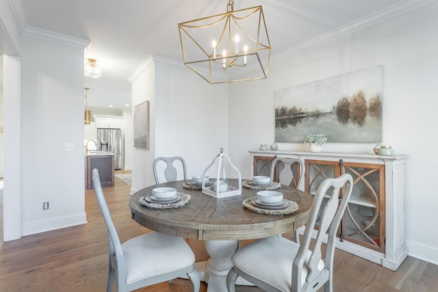 dining room with dark hardwood / wood-style flooring, a notable chandelier, and crown molding