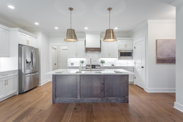 kitchen featuring pendant lighting, stainless steel appliances, custom exhaust hood, and white cabinets