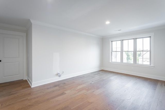 spare room featuring ornamental molding and light wood-type flooring