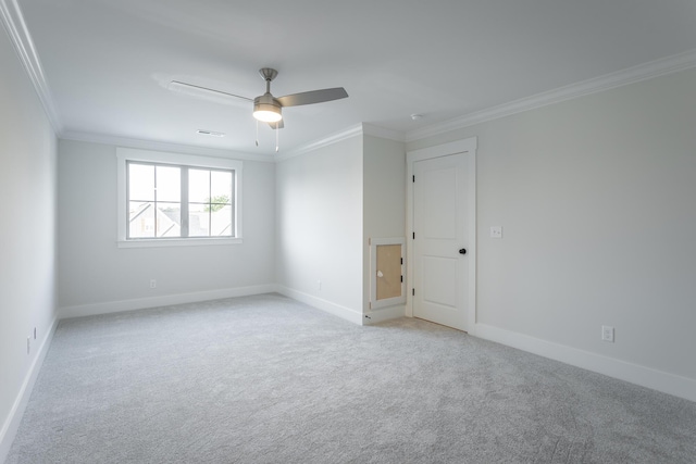 empty room with ornamental molding, light colored carpet, and ceiling fan