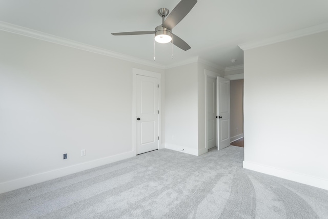 unfurnished room featuring crown molding, light colored carpet, and ceiling fan