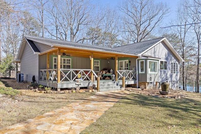 view of front of house with central AC, a front yard, ceiling fan, and covered porch