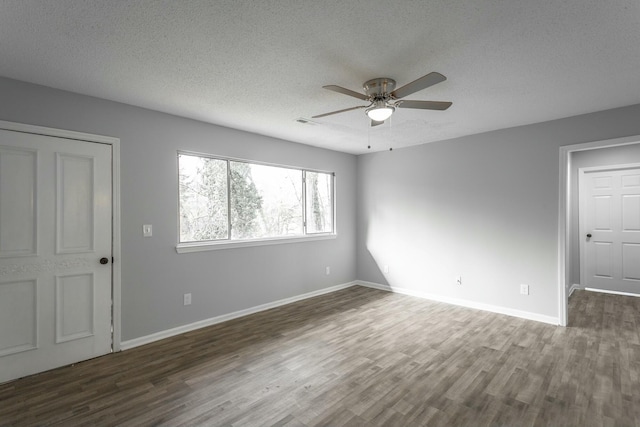 empty room with ceiling fan, a textured ceiling, and dark hardwood / wood-style flooring