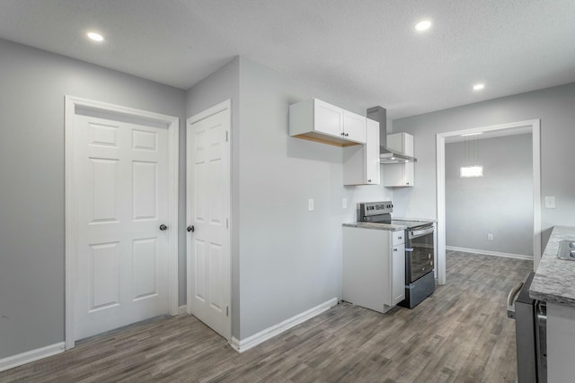 kitchen featuring white cabinetry, hardwood / wood-style floors, stainless steel electric range, and wall chimney range hood