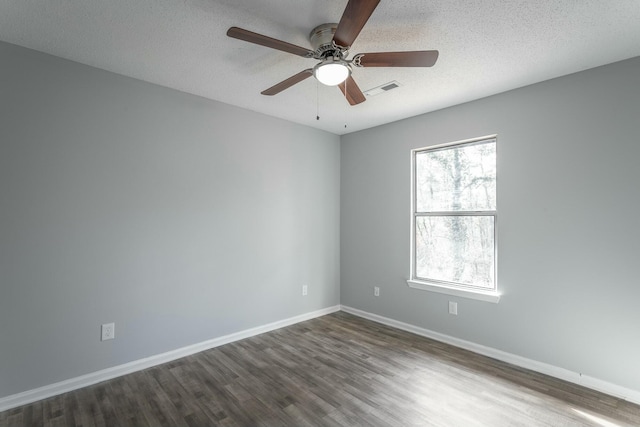 empty room featuring ceiling fan, a textured ceiling, and dark hardwood / wood-style flooring