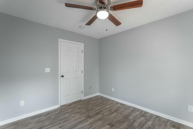 empty room featuring dark wood-type flooring and ceiling fan