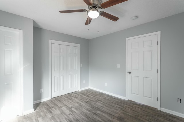 unfurnished bedroom with hardwood / wood-style flooring, ceiling fan, and a closet