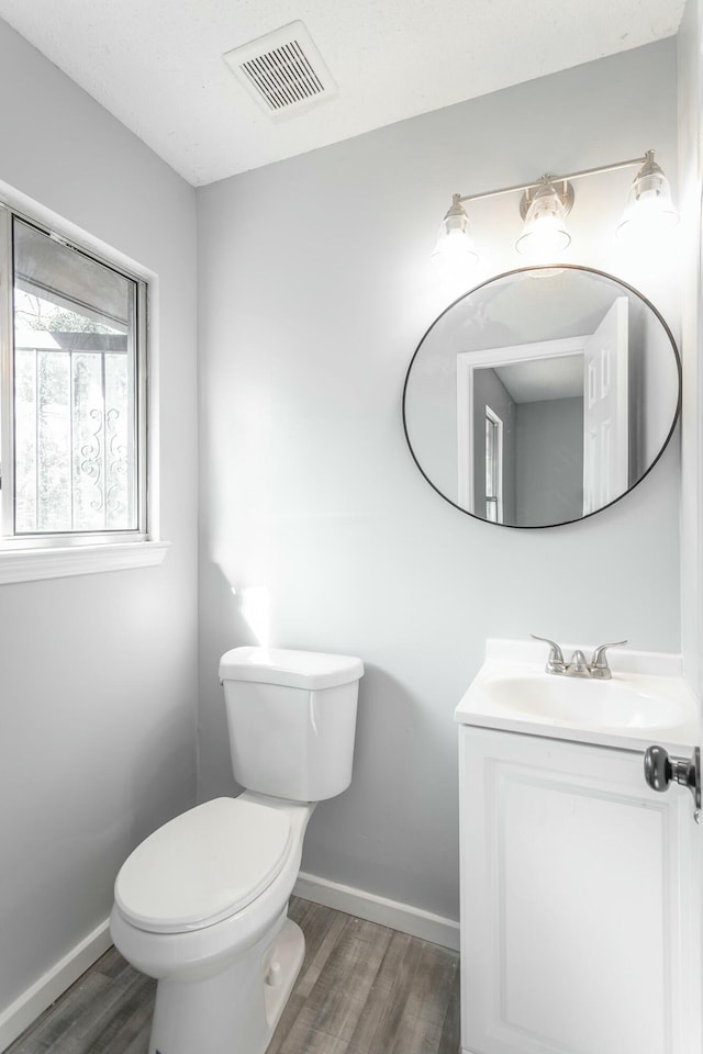 bathroom with hardwood / wood-style flooring, vanity, and toilet