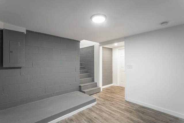 staircase featuring hardwood / wood-style floors and electric panel