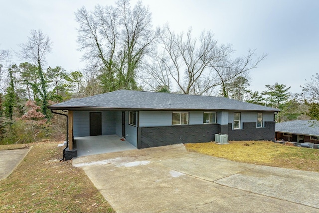 view of front of home with central AC unit and a carport