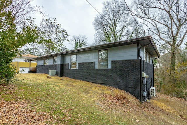 exterior space featuring a yard and central AC