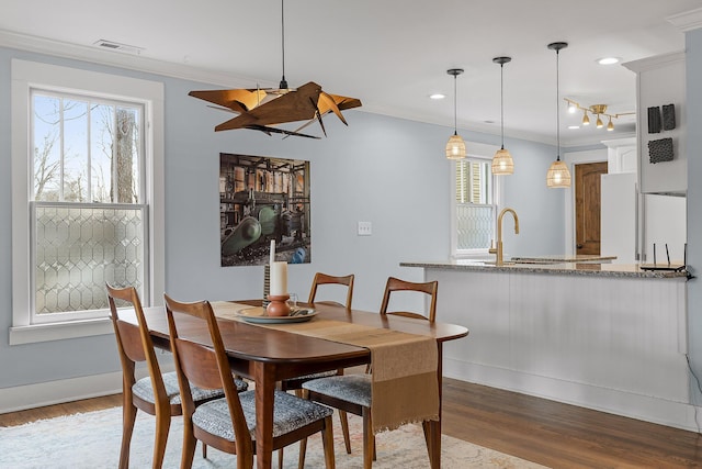 dining space featuring light hardwood / wood-style flooring and ornamental molding