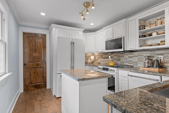 kitchen with stainless steel electric range oven, white cabinets, a kitchen island, decorative backsplash, and white fridge