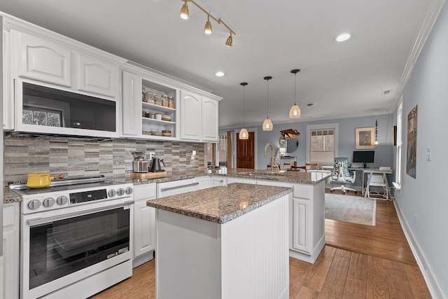 kitchen featuring sink, pendant lighting, a center island, kitchen peninsula, and electric stove