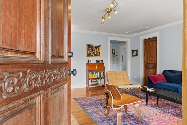 living area with crown molding, track lighting, and light wood-type flooring