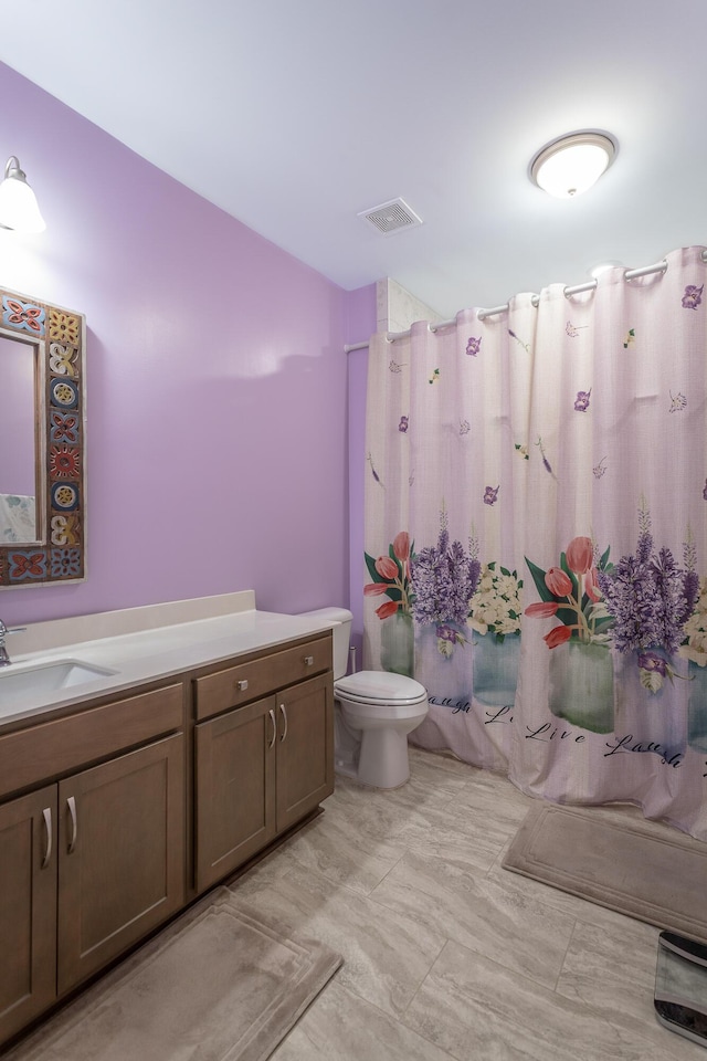 bathroom with vanity, toilet, and curtained shower