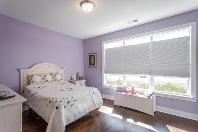 bedroom featuring dark hardwood / wood-style flooring and multiple windows