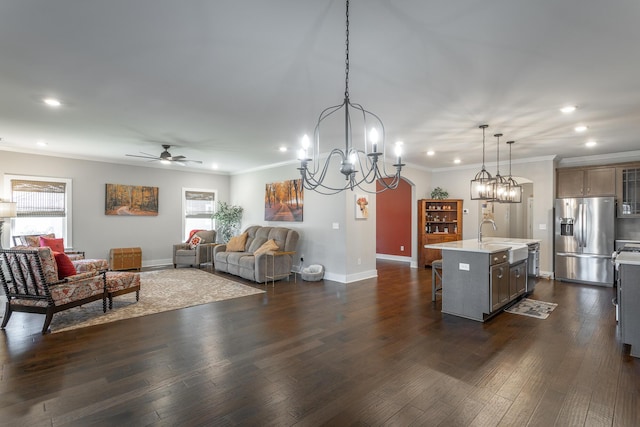 kitchen featuring a kitchen island with sink, hanging light fixtures, stainless steel appliances, a kitchen bar, and dark hardwood / wood-style flooring