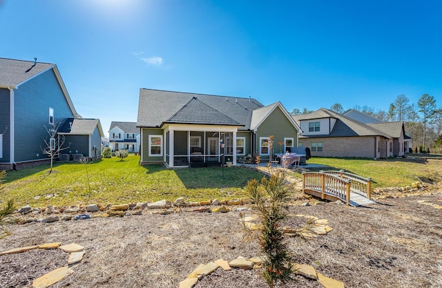 rear view of house with a yard and a sunroom