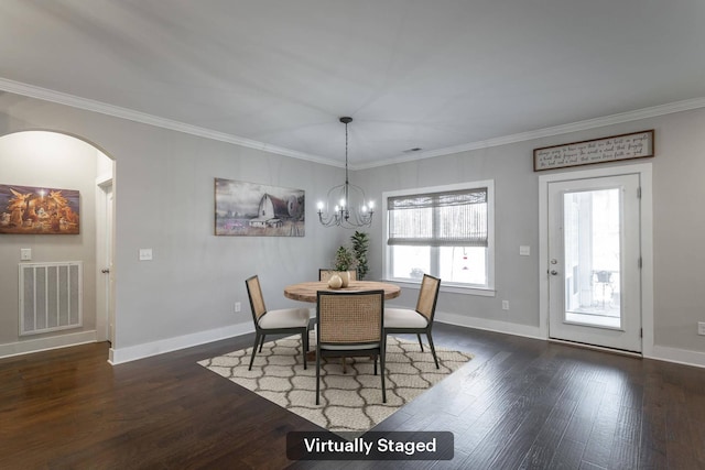 dining area with ornamental molding, dark wood-type flooring, and a notable chandelier